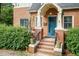 Close-up shot of the front door and entry way, featuring a brick facade and trimmed bushes at 2236 The Cir, Raleigh, NC 27608