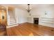 Cozy living room featuring hardwood floors, fireplace, and a staircase leading to the second floor at 2236 The Cir, Raleigh, NC 27608