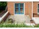 Charming outdoor patio with blue french doors, potted plants, and brick accents at 2236 The Cir, Raleigh, NC 27608