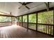 A spacious, screened-in back porch featuring a wood floor and an outdoor ceiling fan at 2236 The Cir, Raleigh, NC 27608