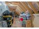 Unfinished attic storage space with exposed beams and various stored items at 230 Paddy Ln, Youngsville, NC 27596