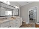 Bathroom featuring double sink vanity with granite countertops, tile flooring, and a walk-in closet at 230 Paddy Ln, Youngsville, NC 27596