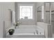 Bathtub featuring tile surround, decorative window, and chrome fixtures at 230 Paddy Ln, Youngsville, NC 27596