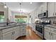 Bright kitchen featuring white cabinets, stainless steel appliances, granite countertops, and natural lighting at 230 Paddy Ln, Youngsville, NC 27596