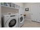 Bright laundry room featuring a side-by-side washer and dryer and overhead shelving at 230 Paddy Ln, Youngsville, NC 27596