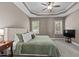 Spacious bedroom featuring a tray ceiling, neutral color scheme, carpet flooring, and natural lighting at 230 Paddy Ln, Youngsville, NC 27596