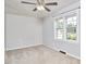 Neutral bedroom features a ceiling fan, large windows, and carpet at 2616 Kirk Rd, Durham, NC 27705