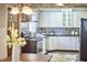 Kitchen with white cabinetry, stainless steel appliances, mosaic backsplash, and black granite countertops at 2616 Kirk Rd, Durham, NC 27705