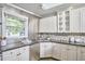 Modern kitchen features white cabinets, stainless appliances, mosaic backsplash, and black granite counters at 2616 Kirk Rd, Durham, NC 27705