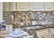 Up close kitchen picture features stainless faucet, black granite countertops, and mosaic backsplash at 2616 Kirk Rd, Durham, NC 27705