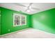 Bedroom featuring bright green walls, a window, ceiling fan, and neutral carpet at 3 Cobble Glen Ct, Durham, NC 27713