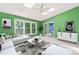 Green bedroom featuring carpet, a sofa, and decor, bathed in natural light from skylights and a large window at 3 Cobble Glen Ct, Durham, NC 27713
