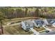 Aerial view showcasing a residence in a well-planned neighborhood, backing onto a lush green area with a pond and trees at 3020 Mavisbank Cir, Apex, NC 27502