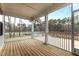 A beautiful, covered wooden deck looks out to a wooded landscape, perfect for relaxing and enjoying nature at 3020 Mavisbank Cir, Apex, NC 27502