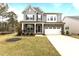 Charming two-story home with gray siding, stone accents, two-car garage, and meticulously kept front yard at 3020 Mavisbank Cir, Apex, NC 27502
