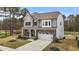 Charming two-story home featuring a stone and siding facade, a covered porch, and a well-manicured front yard at 3020 Mavisbank Cir, Apex, NC 27502