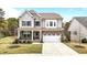 Charming two-story home featuring a stone and siding facade, a covered porch, and a well-manicured front yard at 3020 Mavisbank Cir, Apex, NC 27502