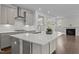 Kitchen island features white countertop, gray cabinets, pendant lighting, and stainless steel range hood at 3020 Mavisbank Cir, Apex, NC 27502