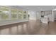 Living room with hardwood floors, large windows, kitchen access, and sliding doors to the outdoor deck at 3020 Mavisbank Cir, Apex, NC 27502