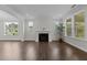 Open living room with a fireplace, recessed lighting, hardwood floors and large windows overlooking the yard at 3020 Mavisbank Cir, Apex, NC 27502