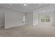 Spacious main bedroom with an ensuite bathroom, a tray ceiling, and a large window at 3020 Mavisbank Cir, Apex, NC 27502