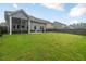 Expansive backyard features lush green grass, a patio with seating, and mature trees, offering a perfect blend of space and privacy at 304 Avery Glenn Way, Fuquay Varina, NC 27526