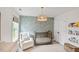 Charming Bedroom featuring a crib, comfortable chair, stylish wallpaper and shelves for displaying books and decorations at 304 Avery Glenn Way, Fuquay Varina, NC 27526