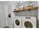 Laundry room with washer and dryer, decorative wallpaper and wood shelf with baskets at 304 Avery Glenn Way, Fuquay Varina, NC 27526