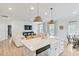 Open-concept living area with eat-in kitchen, stainless appliances, wood floors, and comfortable seating at 304 Avery Glenn Way, Fuquay Varina, NC 27526