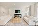 Bright living room featuring wood floors, white sofas, a large coffee table and a TV at 304 Avery Glenn Way, Fuquay Varina, NC 27526