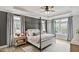 Calming main bedroom showcasing a four-poster bed, tray ceilings, neutral colors, and natural light at 304 Avery Glenn Way, Fuquay Varina, NC 27526