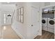 Bright mud room featuring front entry, hallway, and laundry room with stackable washer and dryer at 304 Avery Glenn Way, Fuquay Varina, NC 27526