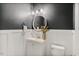 Stylish powder room featuring dark gray walls, white wainscoting, and elegant fixtures at 304 Avery Glenn Way, Fuquay Varina, NC 27526