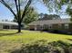 Spacious backyard showcasing the brick house, patio, carport, and mature trees at 305 Briarcliff Dr, Dunn, NC 28334