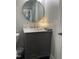 Bathroom vanity features a gray cabinet, marble countertop, and round mirror at 305 Briarcliff Dr, Dunn, NC 28334