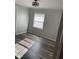 Sunlit bedroom features wood-look flooring and a modern ceiling light at 305 Briarcliff Dr, Dunn, NC 28334