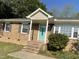 Charming brick home featuring a welcoming turquoise front door and well-maintained landscaping at 305 Briarcliff Dr, Dunn, NC 28334