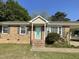 Charming brick home featuring a welcoming turquoise front door and well-maintained landscaping at 305 Briarcliff Dr, Dunn, NC 28334