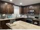 Well-lit kitchen featuring dark wood cabinetry, granite countertops, and stainless steel appliances at 305 Briarcliff Dr, Dunn, NC 28334