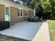 Large concrete backyard patio, brick house and patio furniture with umbrella at 305 Briarcliff Dr, Dunn, NC 28334