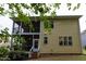 Rear view of home with two-story screened porch, deck, and stairs to backyard; convenient for outdoor enjoyment at 317 Springhurst Ln, Cary, NC 27511