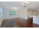 Dining room with hardwood floors, natural light from a window and view into connecting kitchen at 317 Springhurst Ln, Cary, NC 27511