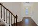Inviting foyer with hardwood floors, staircase, and decorative tree art on the wall at 317 Springhurst Ln, Cary, NC 27511