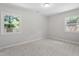 This bedroom features light gray walls, light carpet, and two windows at 3204 Winfield Ct, Raleigh, NC 27610
