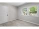 This bedroom has light gray walls, light-colored, wood-look floors, and two windows at 3204 Winfield Ct, Raleigh, NC 27610