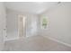 This bedroom features light gray walls, light carpet, a window, and a bathroom at 3204 Winfield Ct, Raleigh, NC 27610