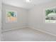 This bedroom features light gray walls, light carpet, and two windows at 3204 Winfield Ct, Raleigh, NC 27610