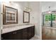Bathroom with dual sink vanity and framed mirrors next to sun room at 344 Colonial Ridge Dr, Pittsboro, NC 27312