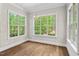 Empty dining room with hardwood floors, decorative trim, and multiple windows offering bright, natural light at 344 Colonial Ridge Dr, Pittsboro, NC 27312
