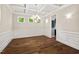 Open dining room space with hardwood floors, coffered ceiling, chandelier and wainscoting at 344 Colonial Ridge Dr, Pittsboro, NC 27312